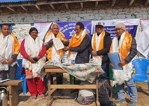 Fünf Personen in feierlicher Kleidung tauschen Dokumente vor einem Gebäude aus.